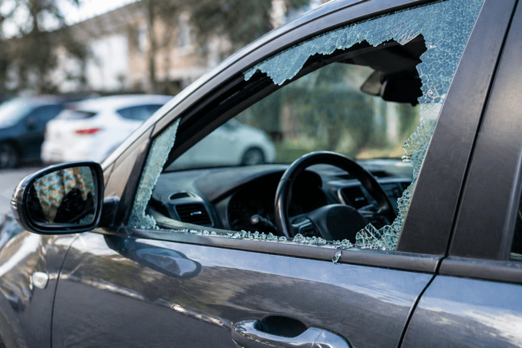 Car with broken window after theft showing shattered glass and vehicle interior exposed